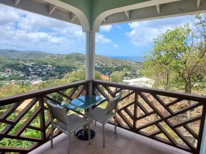 a balcony with two chairs and a table on it at Nia's Hillside Loft - Exquisite Views in Gros Islet