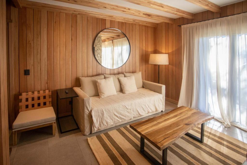 a bedroom with a bed and a mirror and a table at RentUp - Escapate a la Montana, Vila de lujo en San Martin de los Andes in San Martín de los Andes