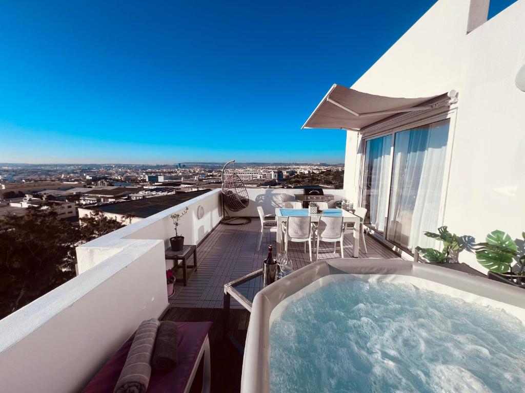 bañera de hidromasaje en el balcón de un edificio en LA88 SweetHome Penthouse with Jacuzzi, en San Ġwann