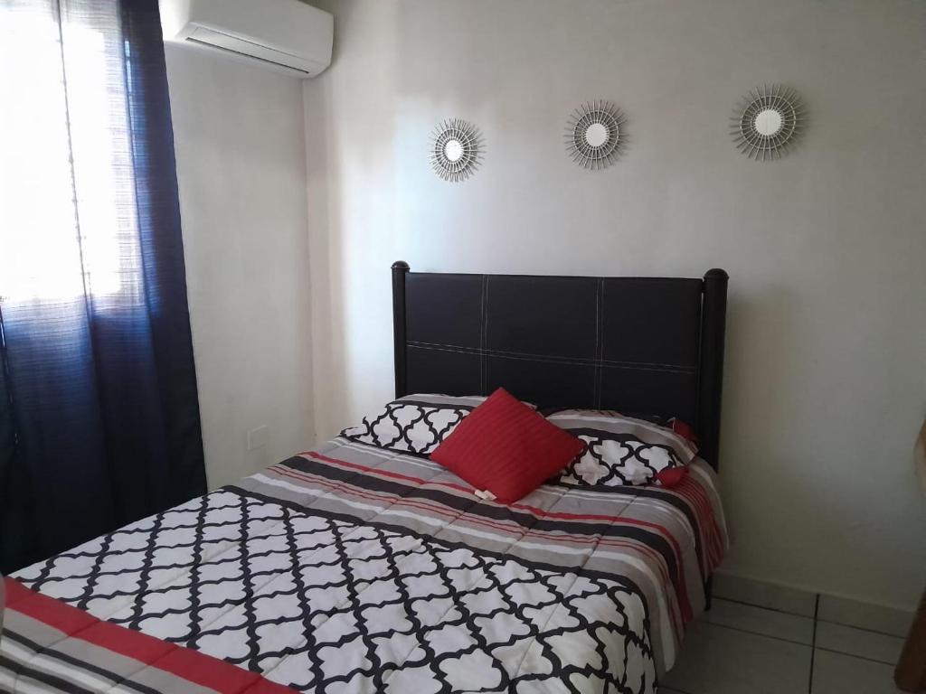 a bedroom with a bed with two mirrors on the wall at Hermosa y cómoda casita super cerca del Estadio El Kraken in Mazatlán