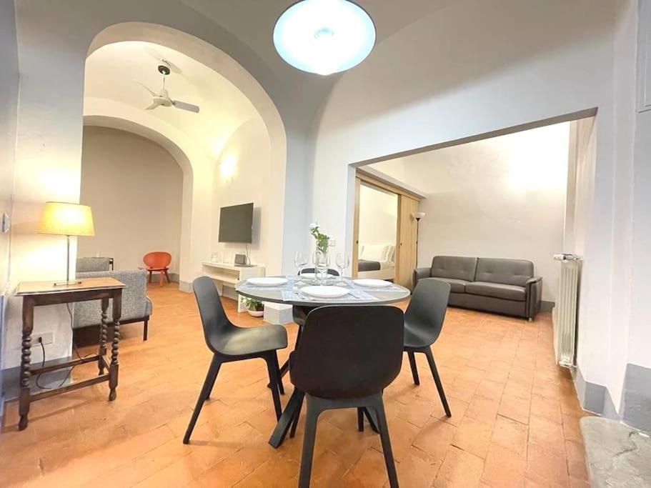 sala de estar con mesa, sillas y sofá en La casa di Ugo-a due passi dal Duomo, en Florencia