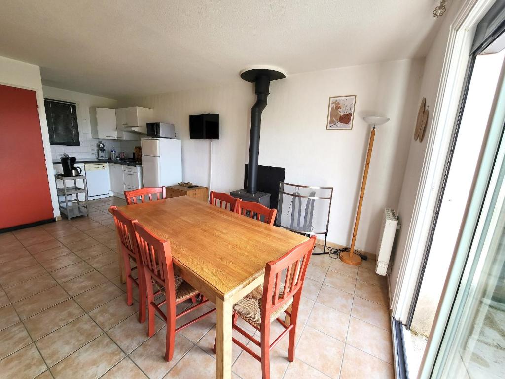 a dining room with a wooden table and chairs at Appartement charmant à La Salvetat-sur-Aout 50 m² avec jardin in La Salvetat