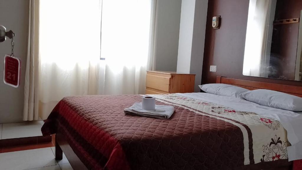 Un dormitorio con una cama con una toalla. en Plaza inn, en Lima