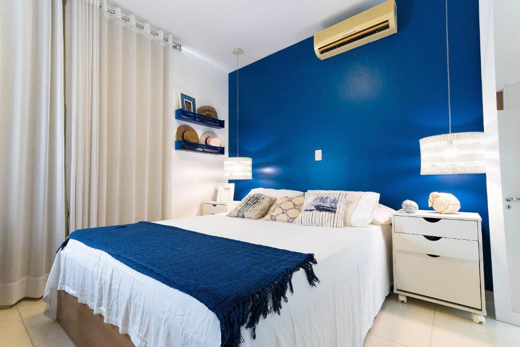 Dormitorio azul con cama y pared azul en Terraços Pirangi #17 - Conforto por Carpediem, en Parnamirim