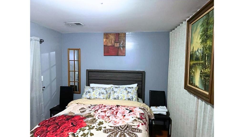 a bedroom with a bed with a red and white blanket at Divine Guest House Room D. 6mins near EWR NEWARK Airport, 4mins to Penn Station / Prudential in Newark