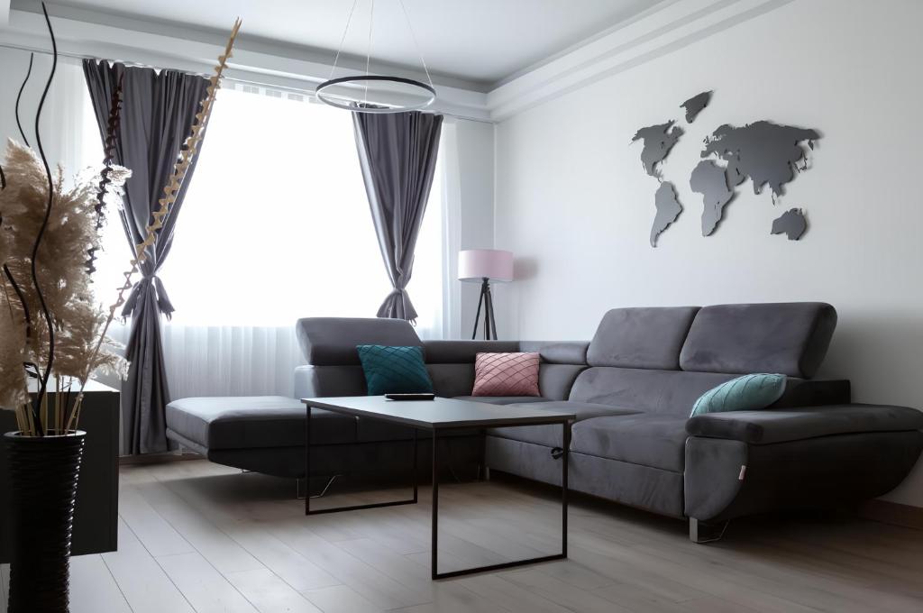 a living room with a couch and a table at Horizon Grey Apartment & Spa in Skopje