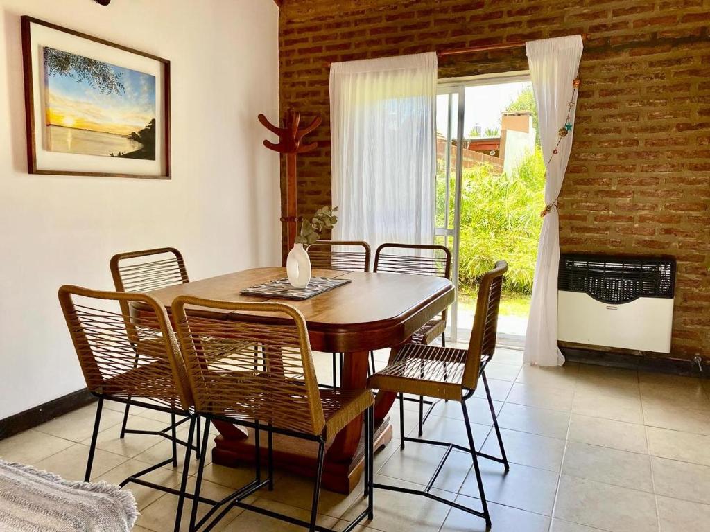 a dining room with a wooden table and chairs at CASA FAUSTINA TRANQUILIDAD y CONFORT EN CHASCOMUS in Chascomús