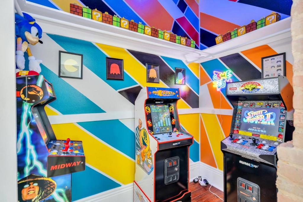 a room with two arcade games and a colorful wall at Retro Arcade Fun At Brick Maison in New Orleans