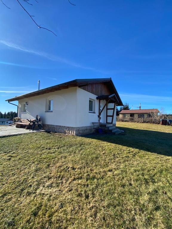 uma pequena casa branca com um jardim relvado em Ferienhaus in Schönheide im schönen Erzgebirge em Schönheide