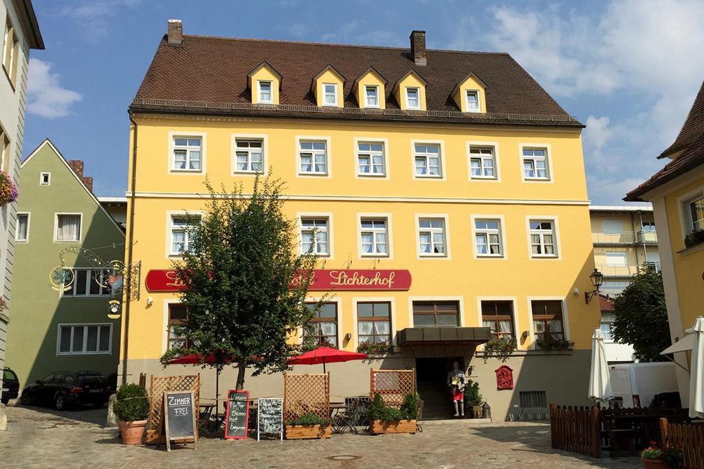 un edificio amarillo con una señal roja. en Landgasthof-Hotel Lichterhof, en Uffenheim