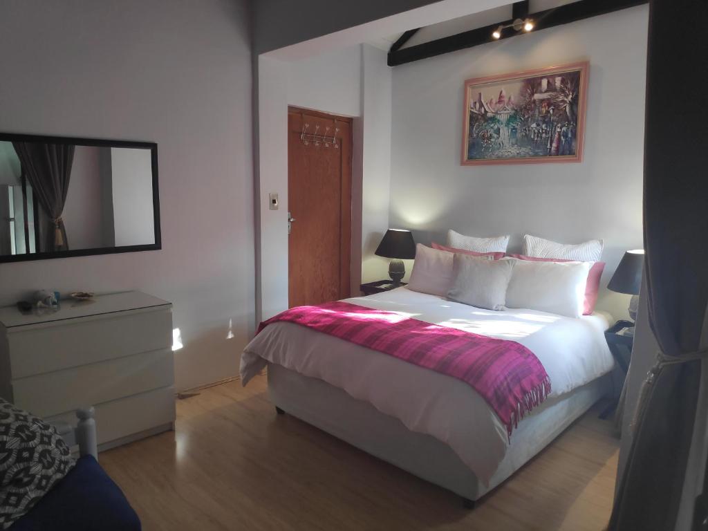ein Schlafzimmer mit einem großen Bett und einem Spiegel in der Unterkunft La Chapelle - The Apartment in Montagu