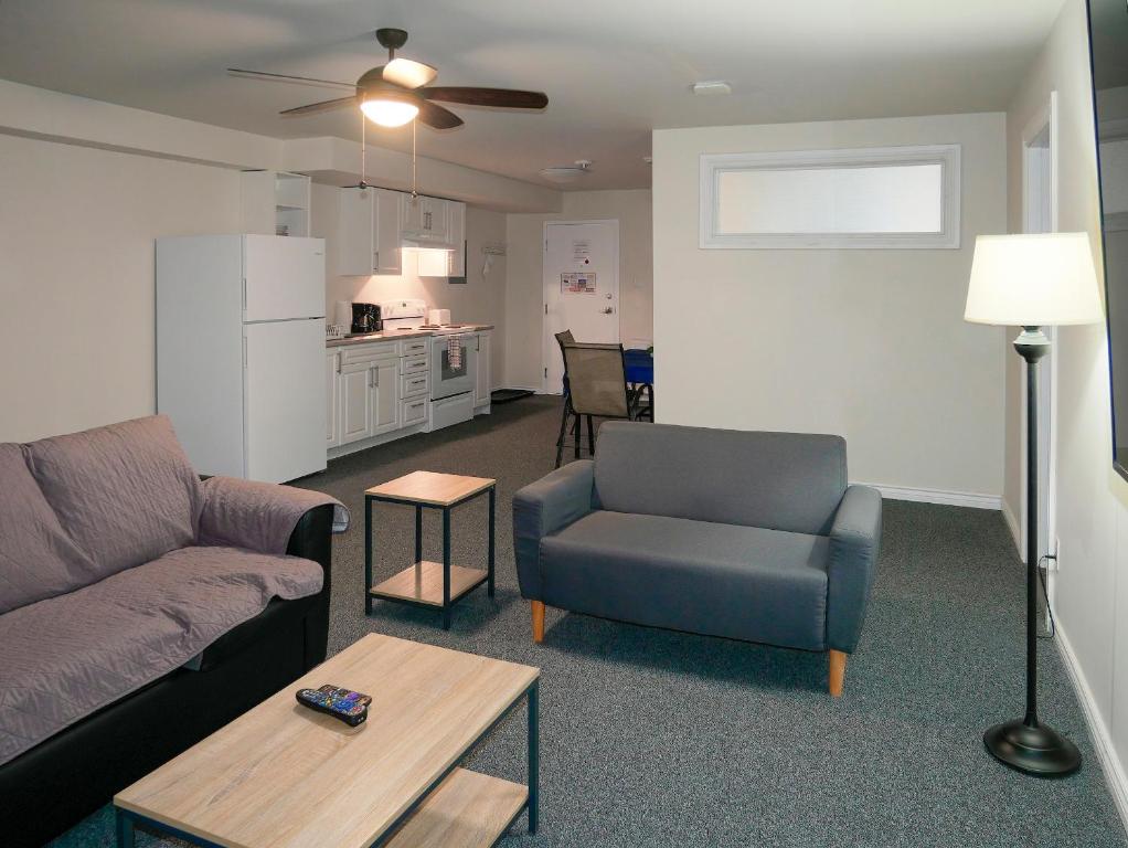 uma sala de estar com um sofá, uma cadeira e uma mesa em Prospectors Inn em Kirkland Lake