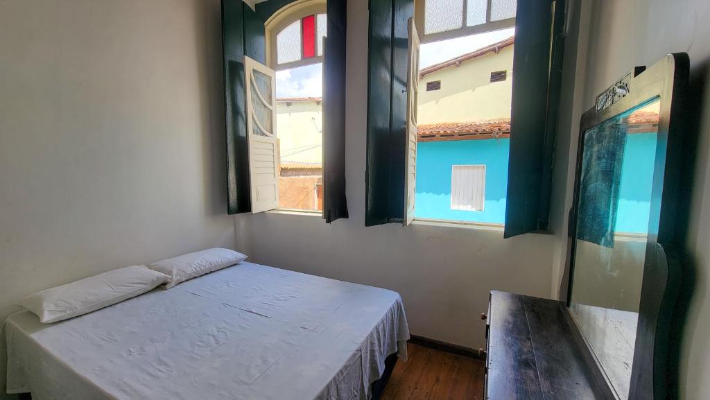 ein Zimmer mit zwei Fenstern und einem Bett darin in der Unterkunft Dona Izaura Estalagem em Lençóis in Lençóis