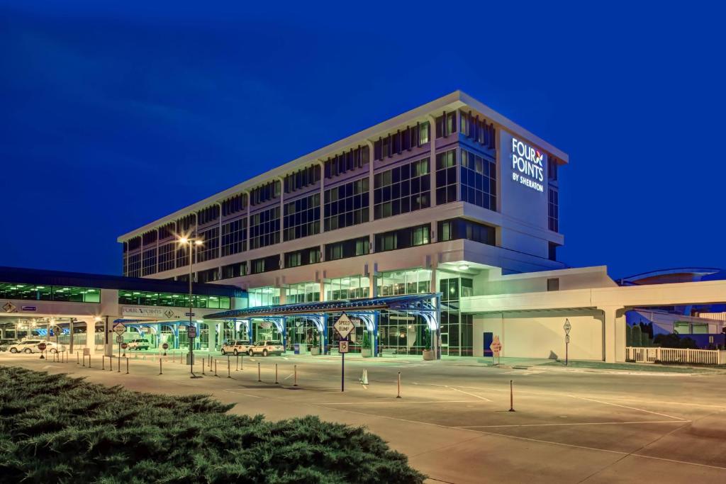 un edificio con un estacionamiento delante de él en Four Points Huntsville Airport, en Madison