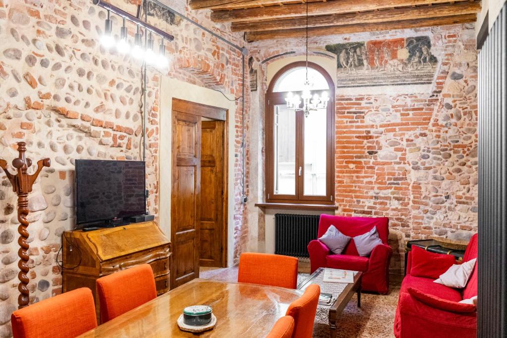 a living room with red chairs and a brick wall at Spazio Seicentesco in Verona