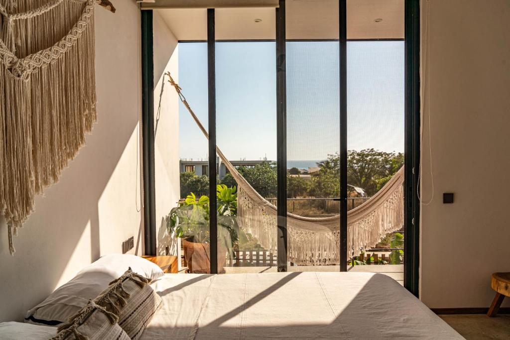 埃斯孔迪多港La Barra Resorts Puerto Escondido的一间卧室，里面有一张床和一扇大窗户。
