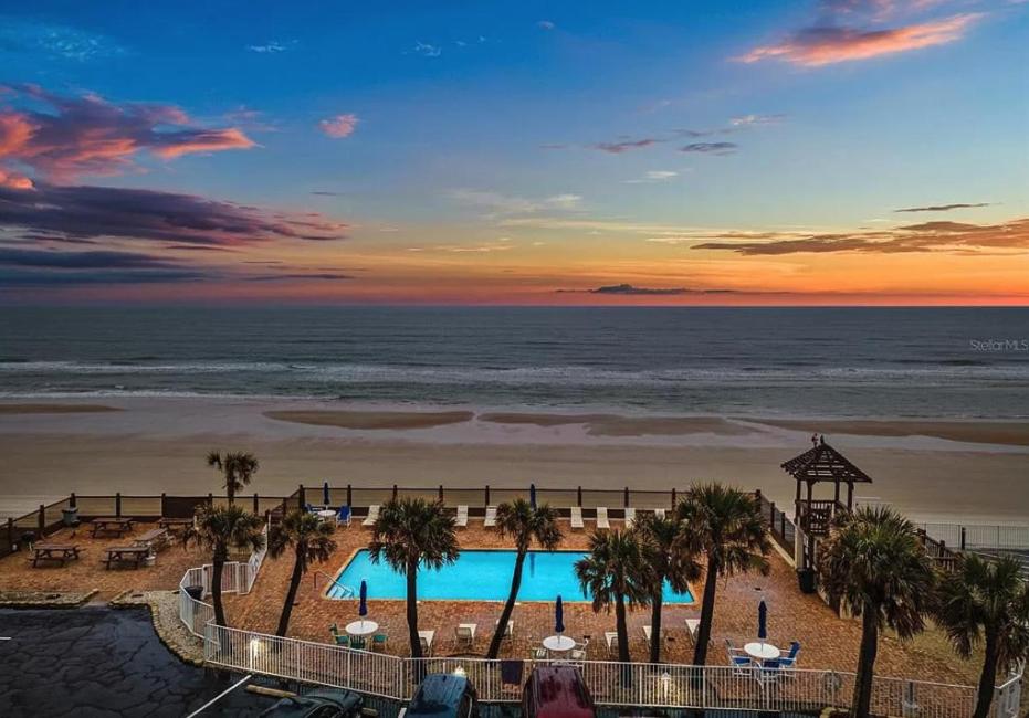 a view of a resort with a pool and the ocean at OCEAN VIEW Condo Daytona Beach in Daytona Beach
