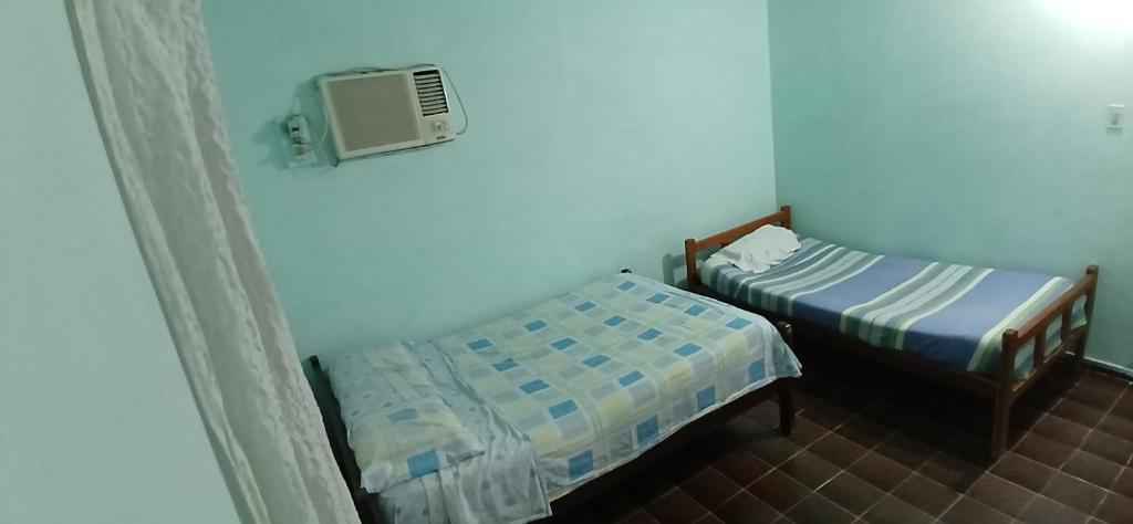 a room with two beds and a tv on the wall at Mburucuya in Mburucuyá