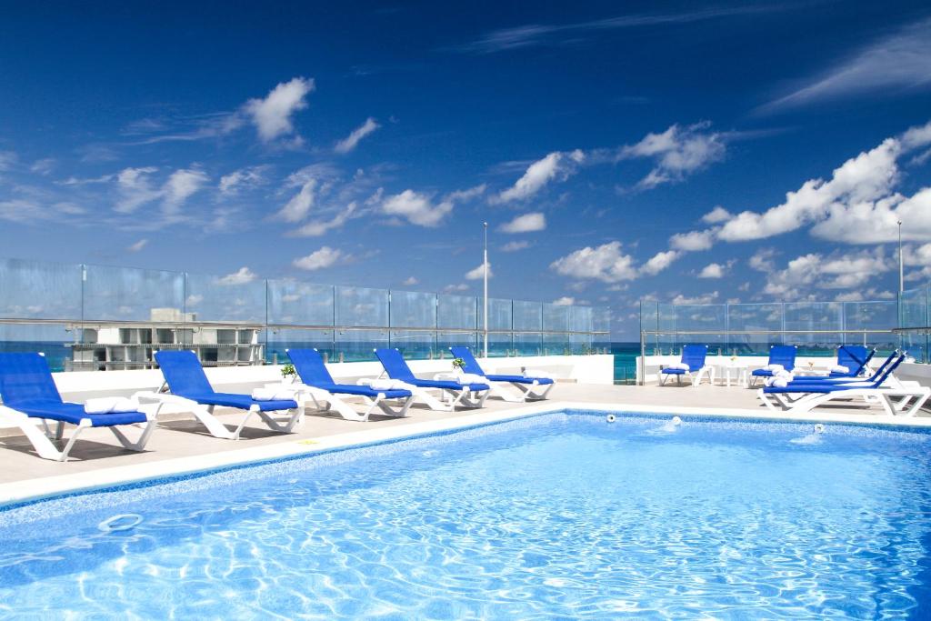 una piscina en la azotea de un edificio con sillas azules en Azure Lofts & Pool, en San Andrés