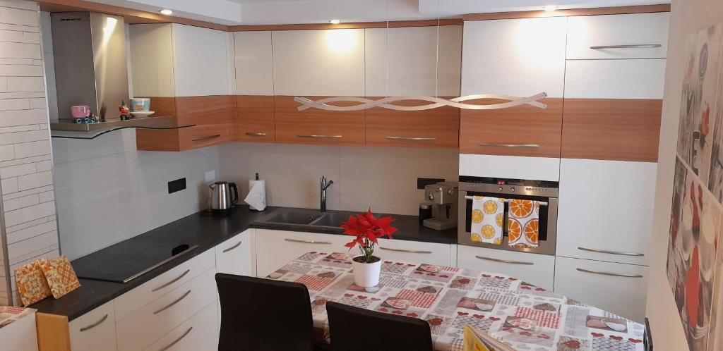 a kitchen with a table with a vase of flowers on it at Casa vacanze Maria in Tesero