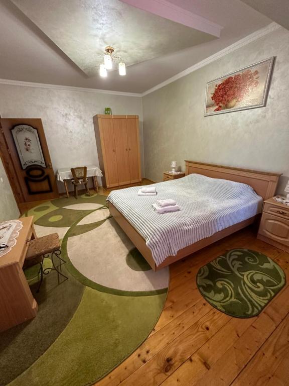 een slaapkamer met een bed en een groen tapijt bij Berizka in Jaremtsje