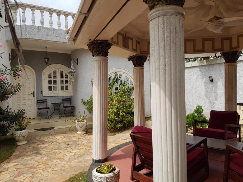a patio with columns and a table and chairs at The Manor in Lomé