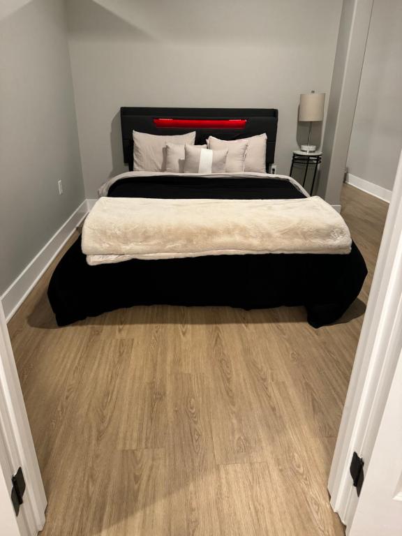 a bedroom with a large bed and a wooden floor at Towson Elite Apartment in Towson