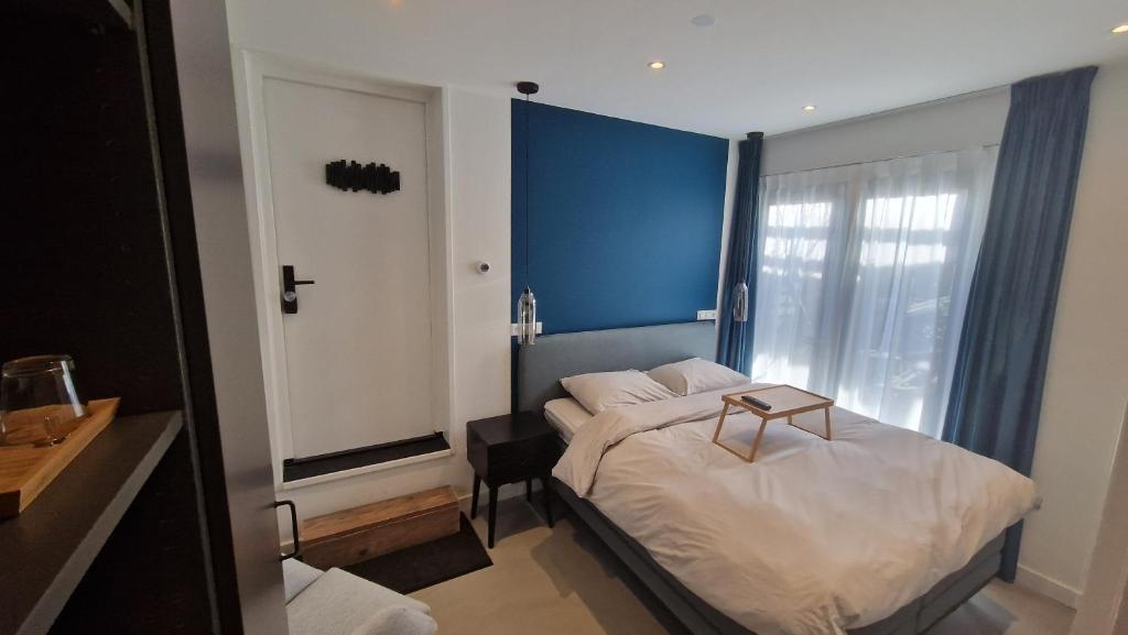una piccola camera con un letto con una parete blu di Het Huis Met De Groene Deur ad Amsterdam