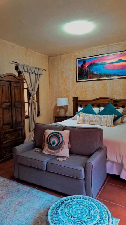 a bedroom with a bed and a couch and a bed at Hotel Boutique Casa Del Ángel in Antigua Guatemala