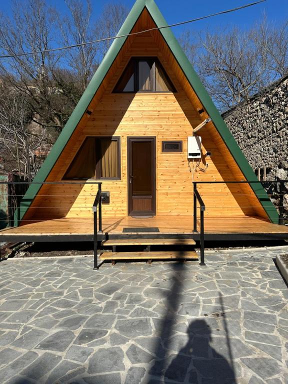 una pequeña casa con un techo puntiagudo con una puerta en Cottage Rioni Kutaisi en Kutaisi