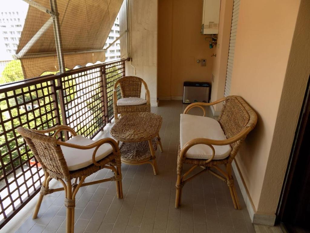 balcón con sillas de mimbre y mesas. en Marco Romani, en Perugia