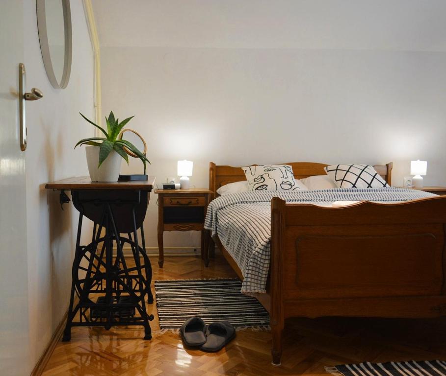 a bedroom with a bed and a table with a potted plant at Apartment Ematours in Požega