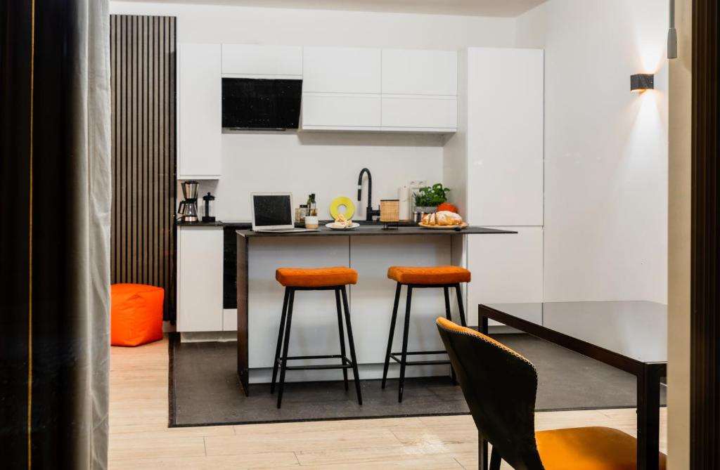 a kitchen with a table and two stools at Bungalow Appartements - "Studio Living" in Haselünne