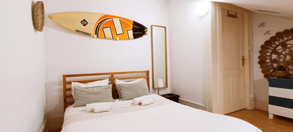 - une chambre avec un lit et une planche de surf sur le mur dans l'établissement Chill and Fun - Matosinhos - ONLY ROOM, à Matosinhos