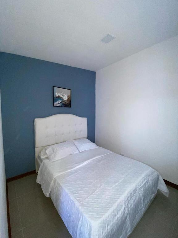 um quarto com uma cama branca e uma parede azul em Tranquilo, Central y acogedor em San José