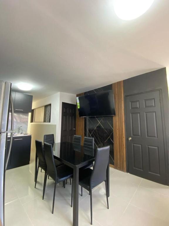a black dining room table with black chairs in a kitchen at Tranquilo, Central y acogedor in San José