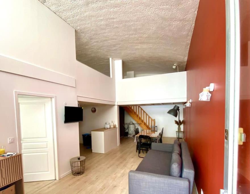 ein Wohnzimmer mit einem Sofa und einer Treppe in der Unterkunft Le Bon Appart à Saint Cyprien in Saint-Cyprien