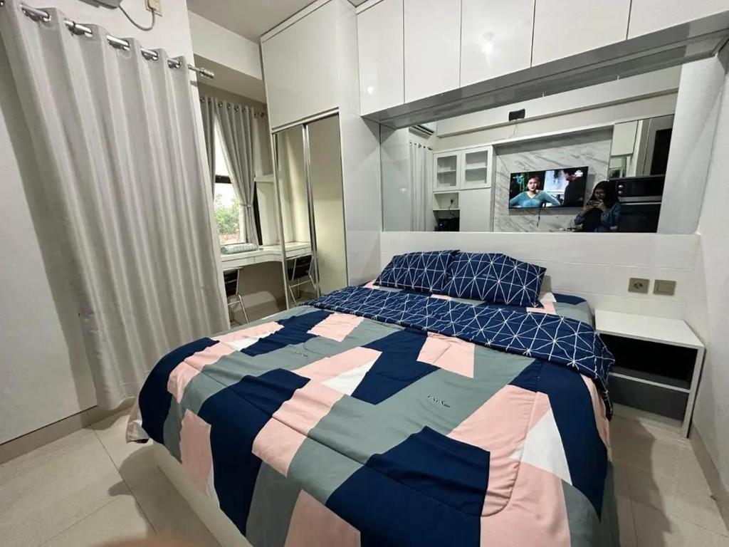 Riz Property في جاكرتا: غرفة نوم بسرير ومرآة