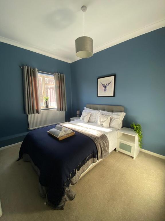 um quarto com uma cama grande e paredes azuis em Pershore Rooms at The Star em Pershore