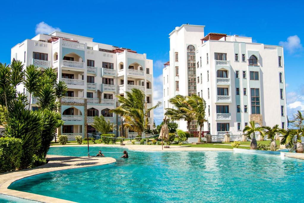 a swimming pool in front of two buildings at Royal Shaza Suites in Shanzu