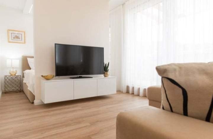 a living room with a flat screen tv on a white cabinet at DIAMOND - Luxusný Apartmán Marco in Podhájska