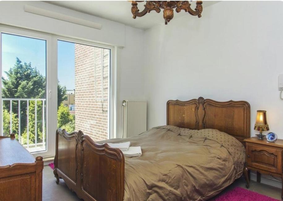 ein Schlafzimmer mit einem großen Bett und einem großen Fenster in der Unterkunft Joseph(ine) in Antwerpen