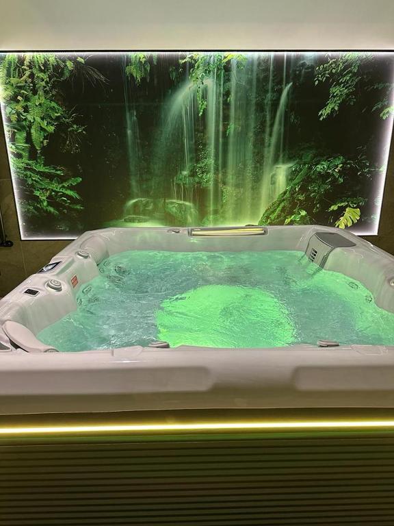 a bath tub with a waterfall in the background at Domek Zakopane Deluxe & Spa na wyłączność in Zakopane