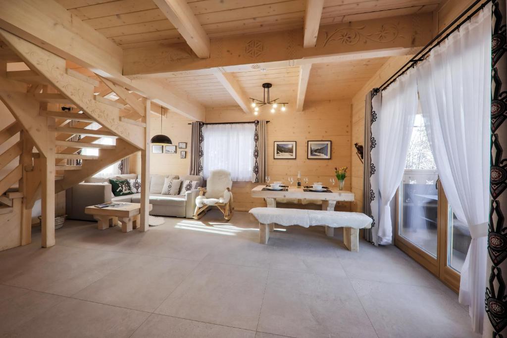 een grote woonkamer met een trap en een tafel bij Domek Zakopane Deluxe & Spa na wyłączność in Zakopane