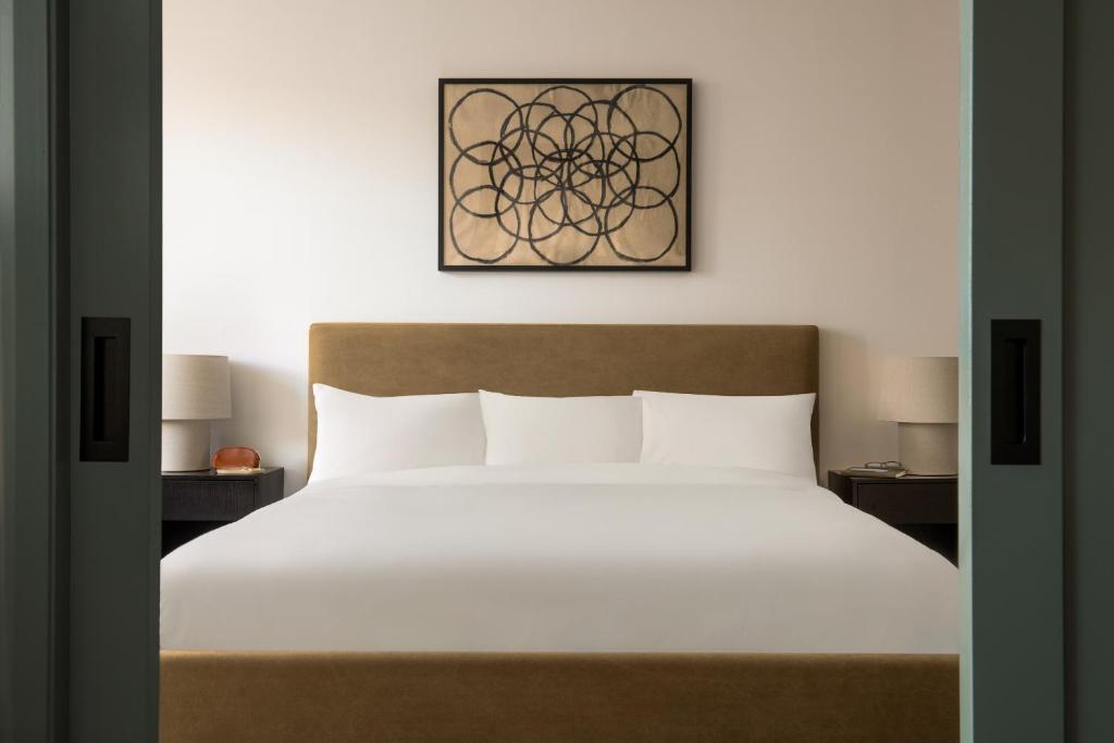 um quarto com uma cama grande e lençóis brancos em Sonder Rideau em Ottawa