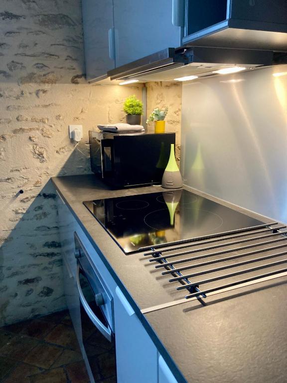 une cuisine avec une cuisinière et un comptoir dans l'établissement maison cocooning, à Gesnes-le-Gandelin