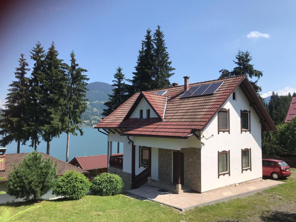 a house with solar panels on the roof at CASUTA LANGA LAC in Colibiţa