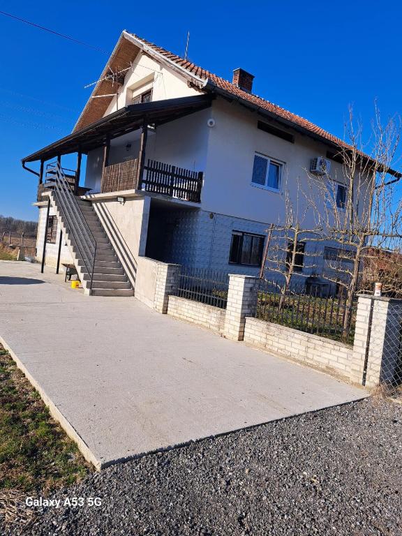 a white house with stairs and a fence at Apartman T&N in Šušnjari