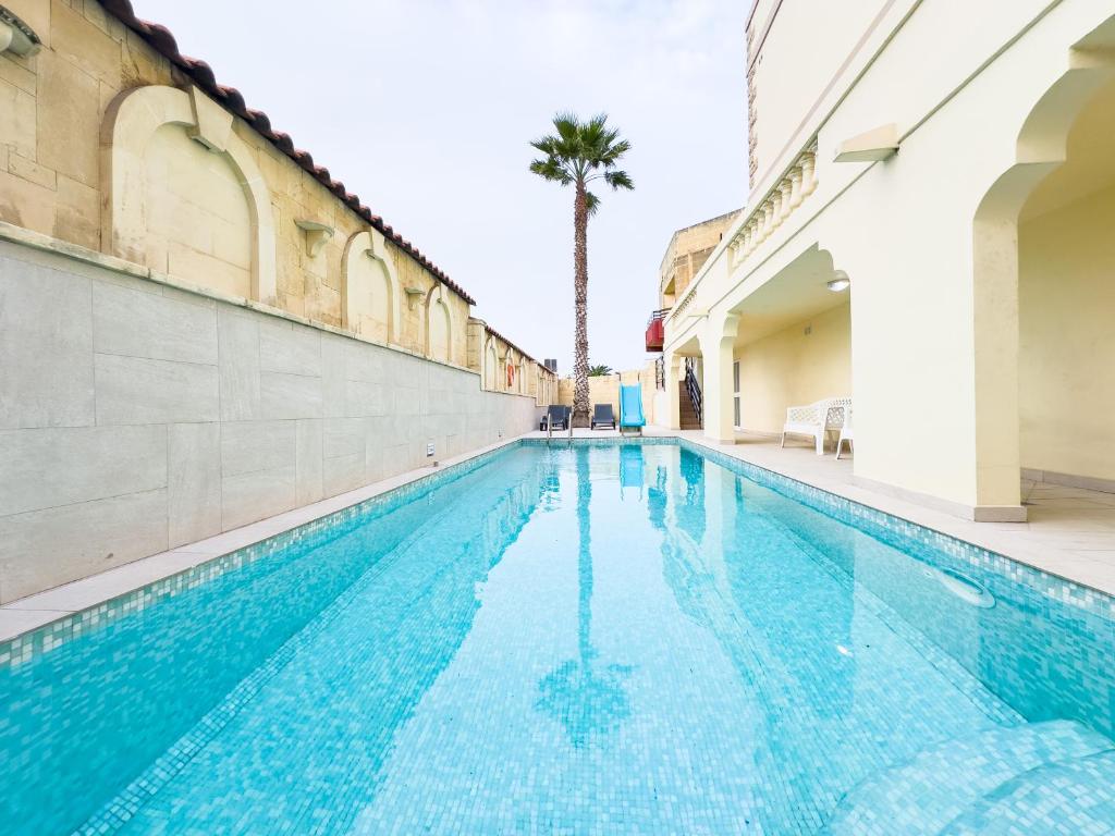 una piscina en un edificio con una palmera en el fondo en Villa in St Julian's with Private Pool, en San Julián