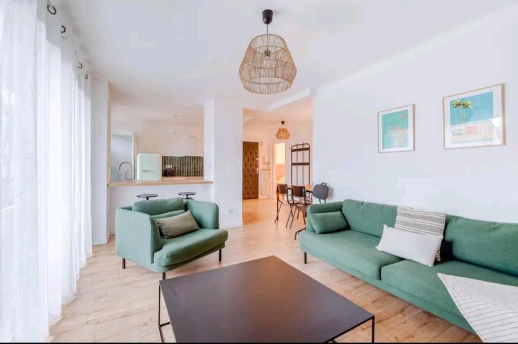- un salon avec deux canapés verts et une table dans l'établissement Bel Appartement - 3 chambres - Proche Gare St Roch, à Montpellier